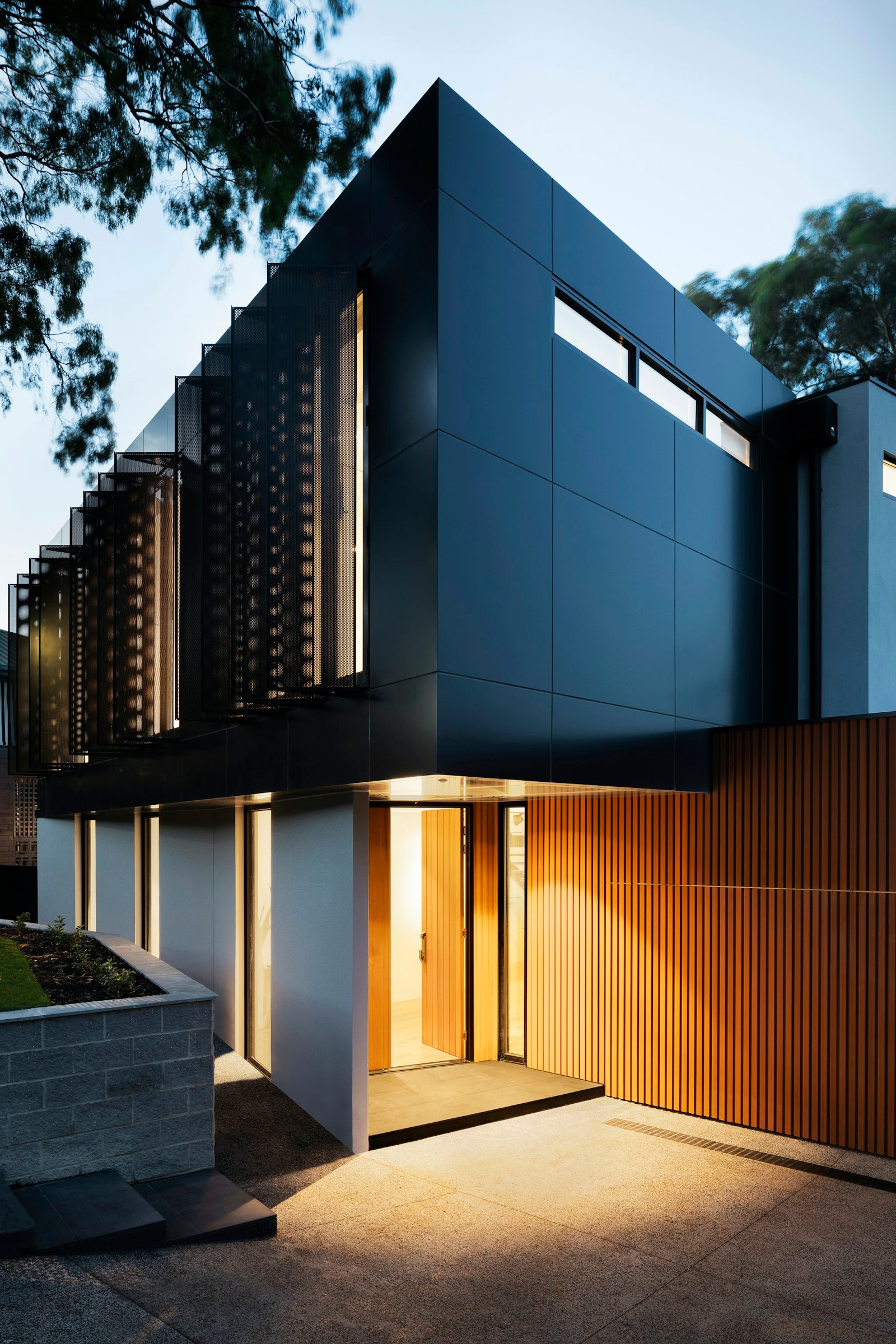 Contemporary house with dark cladding at dusk